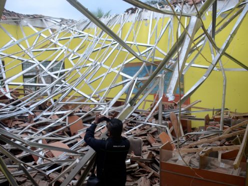 A local journalist films the damage to a classroom at a school following an earthquake in Malang, East Java, Indonesia (Hendra Permana/AP)