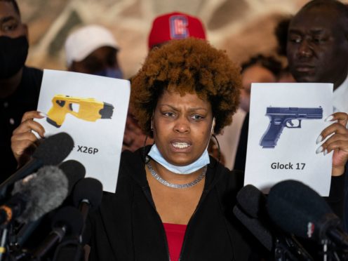 Naisha Wright, aunt of the deceased Daunte Wright, holds up images depicting X26P Taser and a Glock 17 handgun (John Minchillo/AP)