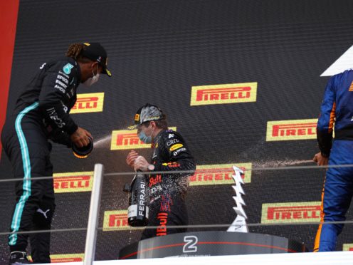 Lewis Hamilton, left, sprays race winner Max Verstappen with champagne on the podium (Bryn Lennon/AP)