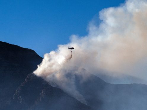 A South African military helicopter drops water on the top of Table Mountain in Cape Town (Jerome Delay/AP)