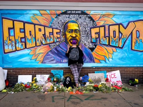 A woman pays her respects at George Floyd at a mural at George Floyd Square in Minneapolis. An application has been lodged to pardon a 2004 drugs conviction against Mr Floyd (Julio Cortez/AP)