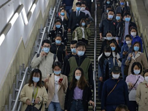 People on an escalator in Beijing (Andy Wong/AP)