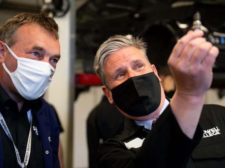 Labour leader Sir Keir Starmer holds a spark plug (Jacob King/PA)