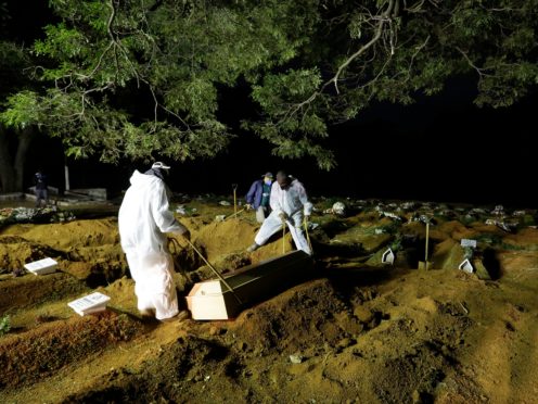 Cemetery workers bury a person who died from complications related to Covid (Nelson Antoine/AP)