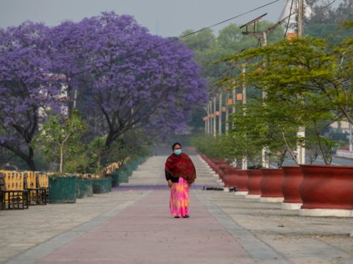 A Nepalese woman walks on a deserted street during the first day of lockdown in Kathmandu, Nepal (Niranjan Shrestha/AP)