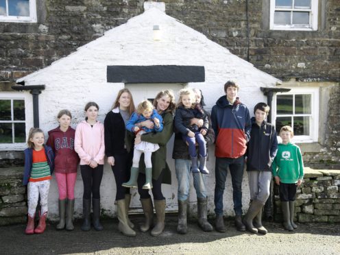 Contributors Amanda and Clive Owen with their children Annas, Violet, Edith, Raven, Clemmy, Nancy, Reuben, Miles, and Sidney outside on Ravenseat Farm (Renegade Pictures)