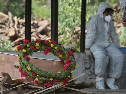 A wreath lies on the coffin of a Covid-19 victim in India (Channi Anand/PA)