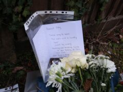 Floral tributes and a card left outside Highdown School in Reading after Olly’s murder (PA)