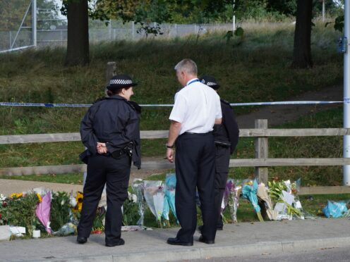 Police officers stand by floral tributes at Cator Park in Kidbrooke (Ian West/PA)