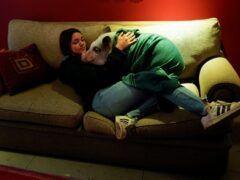 Luciana Benetti, 16, embraces her pet pig Chanchi at home in Buenos Aires, Argentina (Natacha Pisarenko/AP)