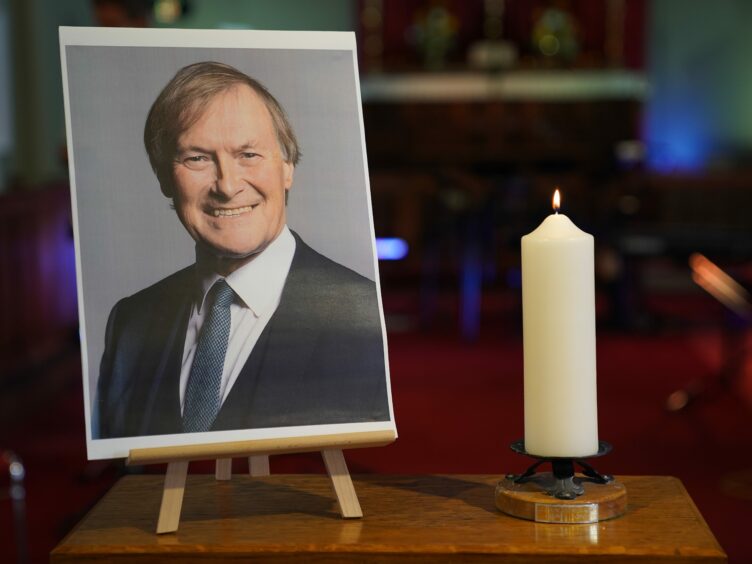 A candle and a photo of Sir David Amess greeted mourners at a vigil in Essex (Kirsty O’Connor/PA)
