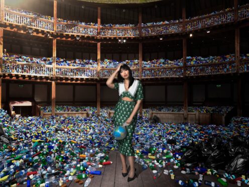 Daisy Lowe poses in Shakespeare’s Globe which has been filled with plastic waste to show the effects of human activity (National Lottery/PA)