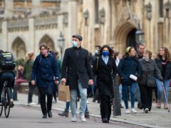 People wear face masks as they walk along Kings Parade in Cambridge (Joe Giddens/PA)