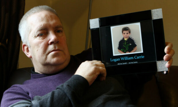 Mr Brown with a picture of his grandson Logan Carrie. Image: DC Thomson.
