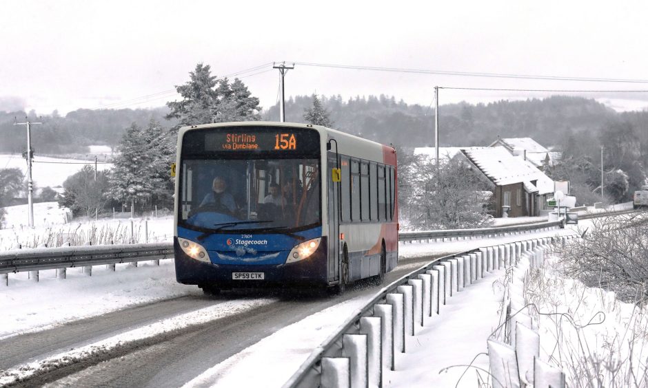A bus drives through snowy conditions close to Greenloaning in Perthshire. Image: PA