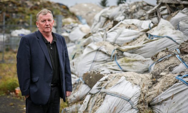 Labour MSP Alex Rowley beside mounds of waste at the Lathalmond rubbish dump site in 2018.