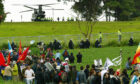 Police reinforcements (top) are drafted in by helicopter, after protestors breached the security fence surrounding the G8 summit at Gleneagles in July 2005. Image: PA