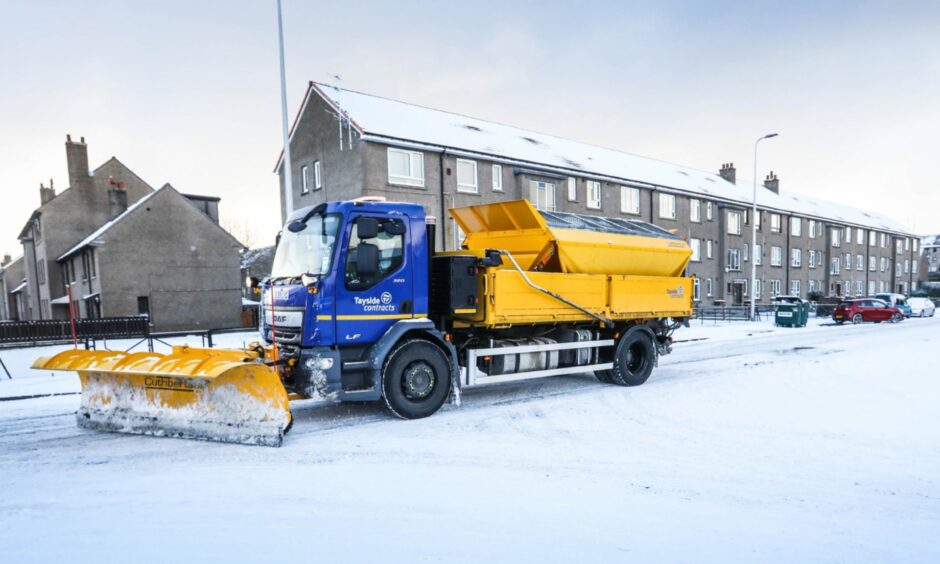 A gritter driving through a snowy Dundee.