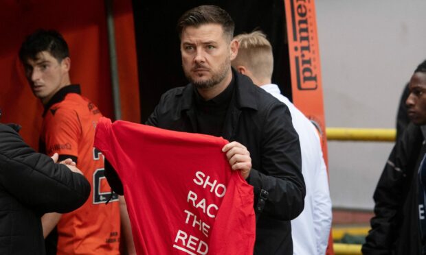 Tam Courts held up a Show Racism The Red card t-shirt after Dundee United's win over Ross County