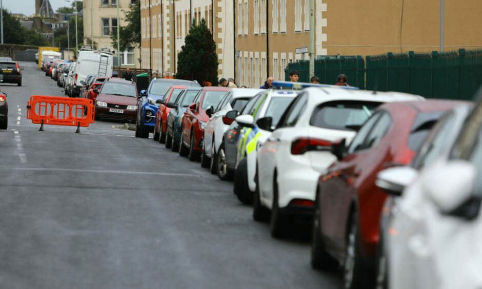 Cars parked along one side of a street in Dundee