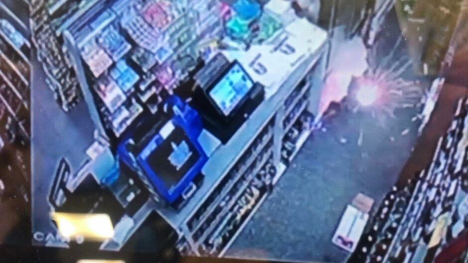 A still from CCTV footage of a firework exploding inside a Dundee shop