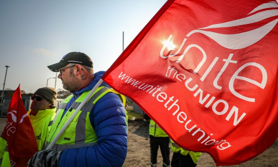 A Unite union member holding a red flag during a protest