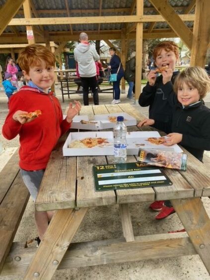 Photo shows Martel Maxwell's three young sons eating pizza at a picnic table.