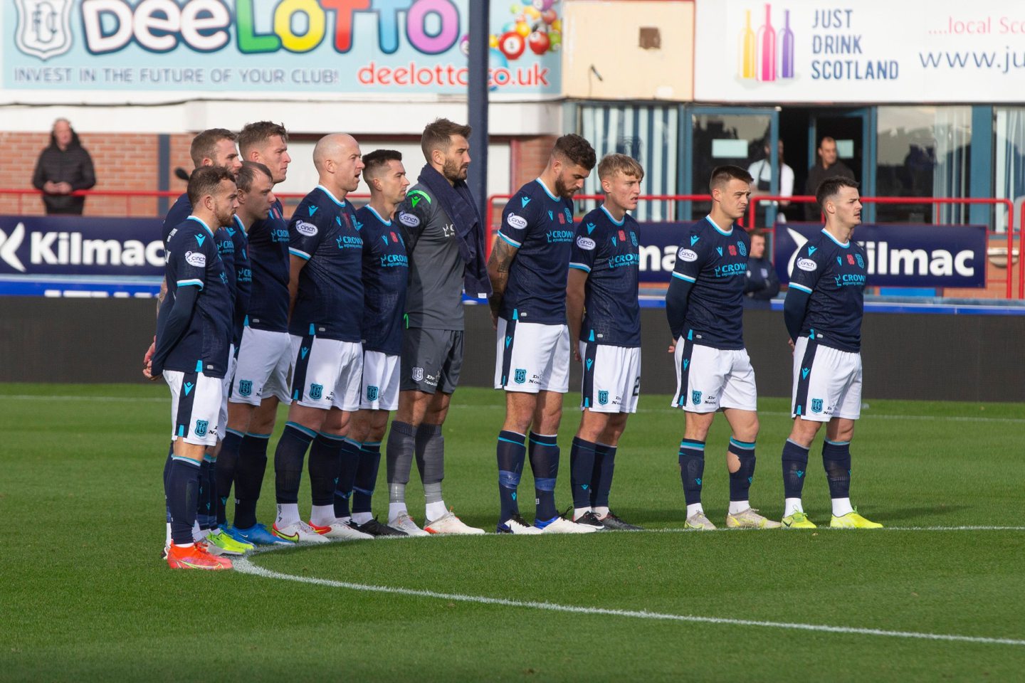 Dundee players observing the minutes silence at Dens Park before the match.