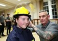 Volunteer insturctor Scott Arcari kits out Jamie Hepburn in her fire fighting gear at the launch of the Youth Volunteer Scheme