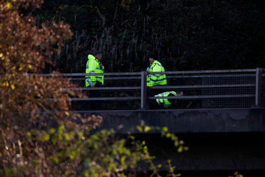 Police inspecting the damaged barrier at the scene of a lorry crash on a flyover near Perth.