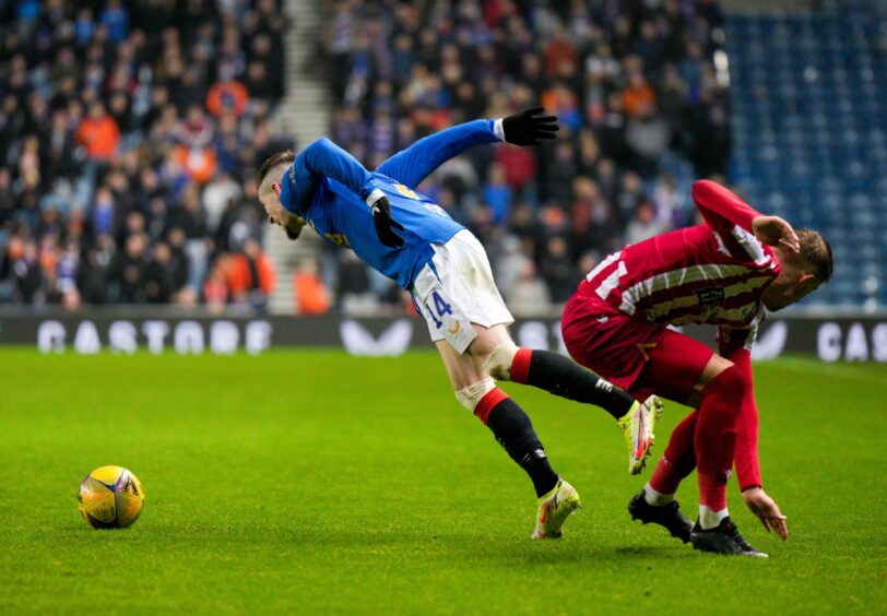 Reece Devine challenges Ryan Kent.