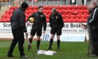 Referee Steven McLean chats with the ground staff before calling Saturday's game off.