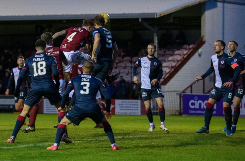 Ricky Little and Christophe Berra clash head as they go for the ball.