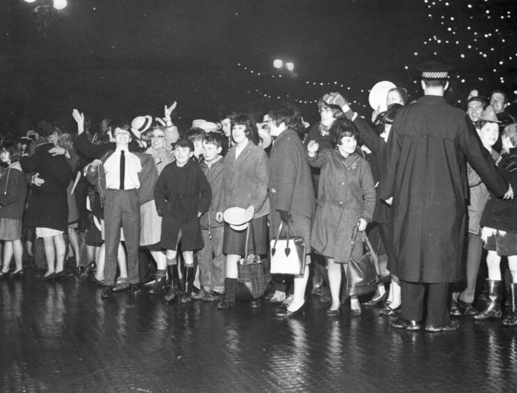 Photo is a black and white image from 1966 showing young people at a Hogmanay party in Dundee City Square.