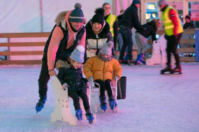 A family enjoying the ice rink at Dundee Winterfest.