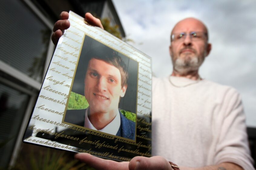 Phil Welsh holding a photo of his son Lee, who died from suicide