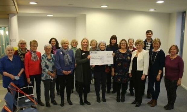 Cath Young, centre right, presents the £5,500 cheque to Vikki Merrilees of Cancer Research UK.