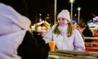 Happy people with hot drink on a visit to Dundee Winterfest