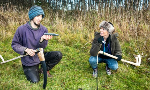 Gayle sharpens her skills at scything with Caspar Lampkin. Picture: Steve Brown.
