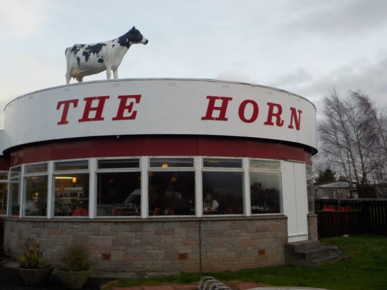 exterior of The Horn milk bar with model cow on roof.