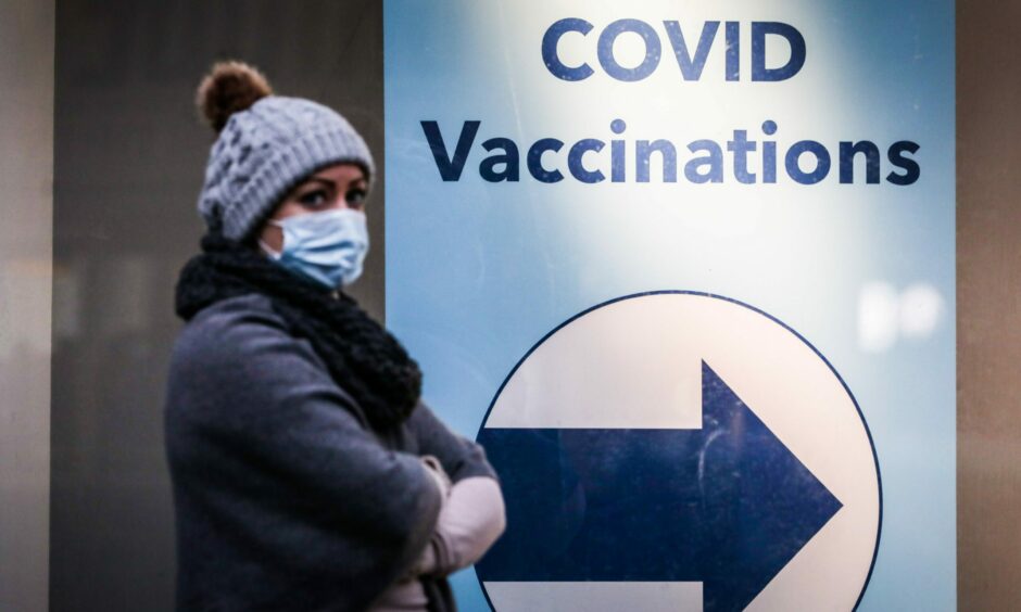 A woman waits in a outside Covid vaccine site 
