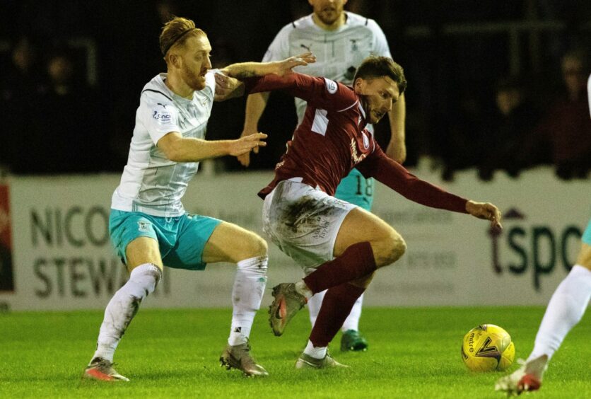 Michael McKenna holds off a challenge from Inverness' David Carson.