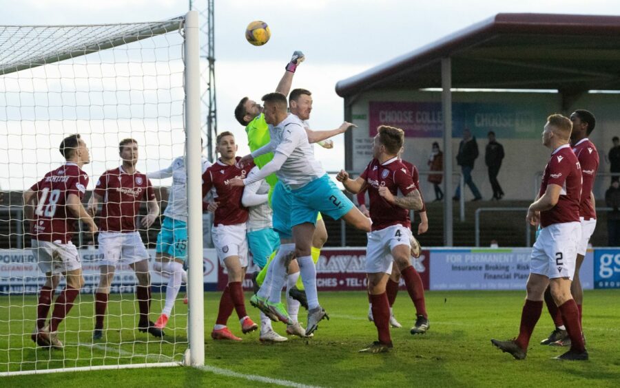 Derek Gaston attempts to punch clear under pressure from Inverness' Shane Sutherland during the New Years' clash at Gayfield.