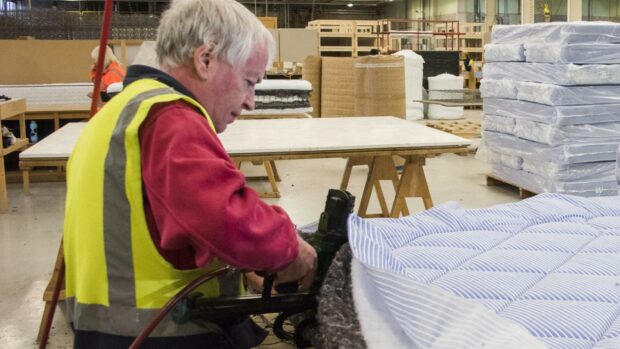 Employee at Dovetail Enterprises in Dundee making a mattress to order.