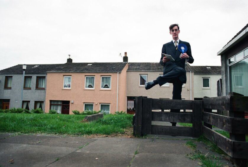 Jacob Rees-Mogg stepping over a garden gate in Leven, Fife, while canvassing during the 1997 general election campaign.