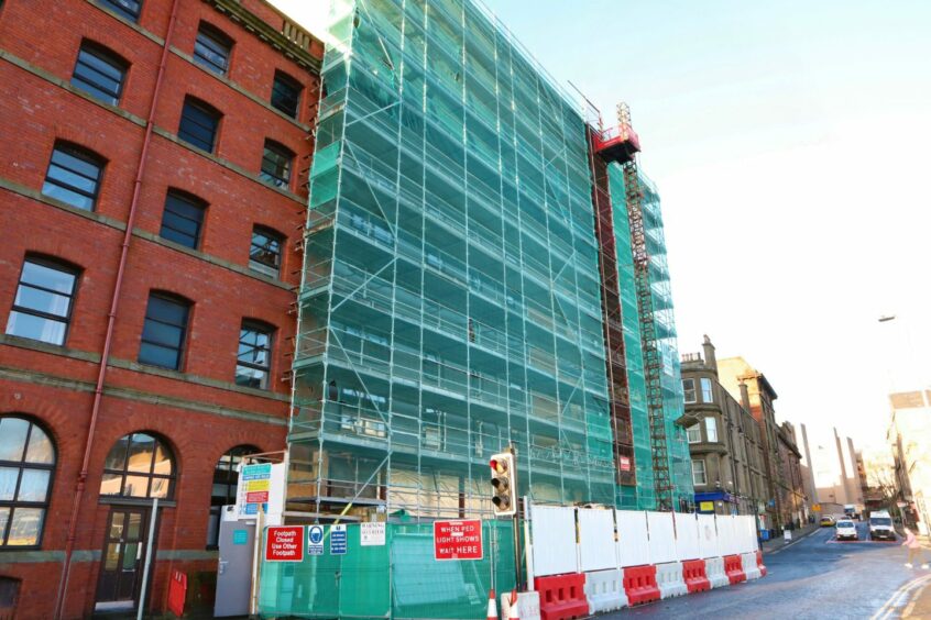 The building remains surrounded by scaffolding.