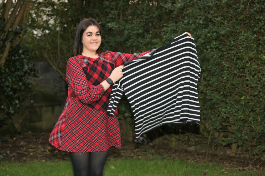 Montrose woman Zoe lost 9 stone on the Slimming World vegan diet. Zoe holds up a shirt from before her weight loss, showing her difference in size. 