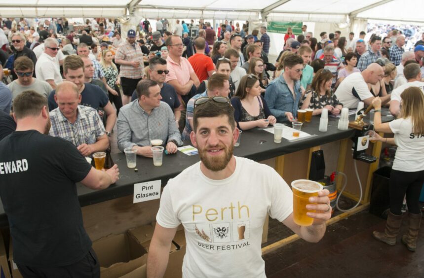 Perth teacher Adam Pattinson holding up a pint at Perth Beer Festival.