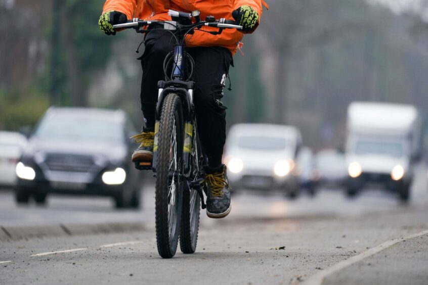 A cyclist on a busy road. 