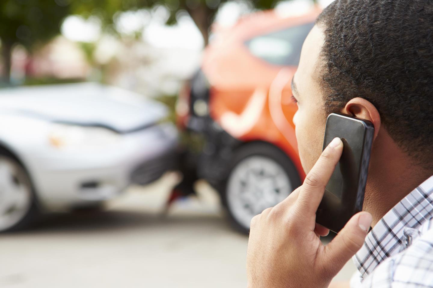 man on phone at car accident